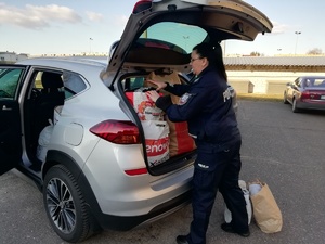 policjantka  pakuje do samochodu torby z przekazanymi rzeczami od policjantów dla ukraińskich rodzin