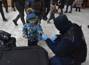 Policjant wręcza małemu dziecku odblask