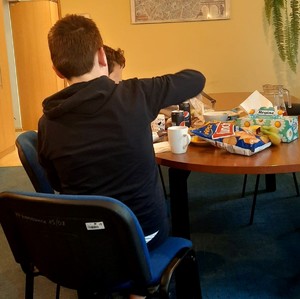 dwóch ukraińskich chłopców siedzących przy stole w komisariacie spożywających posiłek