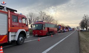 autokar oraz wozy strażackie stoją na poboczu drogi