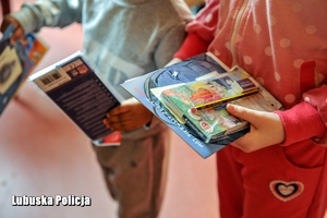 Dzieci trzymają kolorowanki i kredki