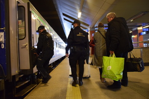 Policjant pomaga wnieść walizkę mężczyzny