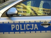 fragment policyjnego radiowozu - widok z boku na którym widać napis Policja