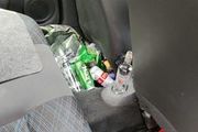 puste butelki i puszki po alkoholu za fotelem kierowcy