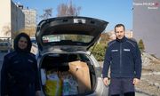 Komendant i policjantka na tle radiowozu z darami dla mieszkańców Ukrainy