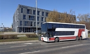 Autobus stojący na jezdni na tle budynku komisariatu na Krzykach