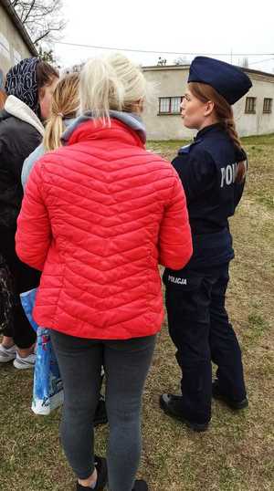 Zdjęcie przedstawia policjantkę rozmawiającą z grupką osób z Ukrainy