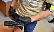 policjant trzyma zabezpieczoną broń