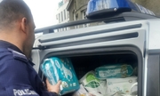 policjant wyjmuje paczki z darami z radiowozu