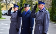 trzej umundurowani policjanci oddają hołd salutując