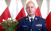 Komendant Główny Policji na tle flag Polski