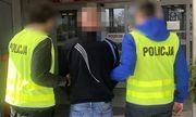dwaj policjanci w kamizelkach odblaskowych prowadzą zatrzymanego do prokuratury w Katowicach