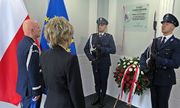 Komendant Główny Policji i kobieta z rodziny zmarłej Marii Czernek przed tablicą jej imienia