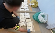 policjant układa woreczki z narkotykami na podłodze