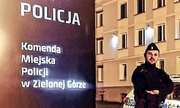Umundurowany policjant stojący przy banerze