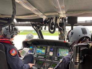 Policyjni lotnicy w kokpicie śmigłowca Black Hawk przygotowują się do startu