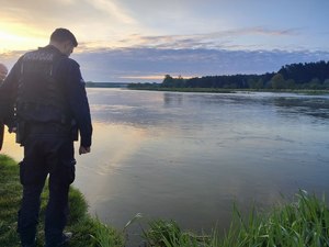 policjant stoi nad rzeką