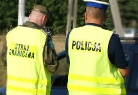 Strażnik graniczny i policjant w żółtych kamizelkach - widok z tyłu