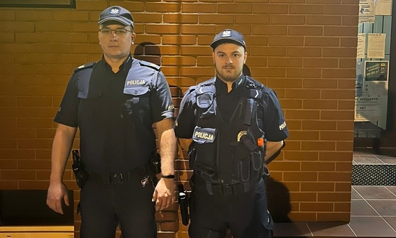 dwóch umundurowanych policjantów stoi pod budynkiem Komisariatu Policji w Kaletach