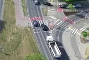 Samochód osobowy wyprzedza inny samochód osobowy na przejściu dla pieszych - widok z drona