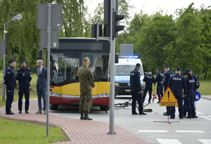 grupa policjantów i żołnierz, w tle autobus i radiowóz