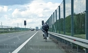 Rowerzysta jadący pasem awaryjnym po drodze ekspresowej