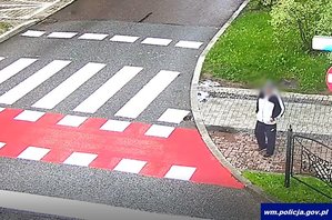 Zrzut ekranu z monitoringu, na którym widać poszukiwanego mężczyznę obok przejścia dla pieszych