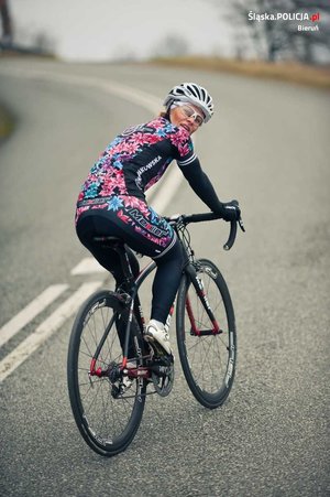Zdjęcie prywatne Weroniki Nowakowskiej. Kobieta w stroju kolarskim i w kasku na głowie jedzie jezdnią na rowerze. Głowę ma odchyloną do tyłu, przez co twarz widać na zdjęciu