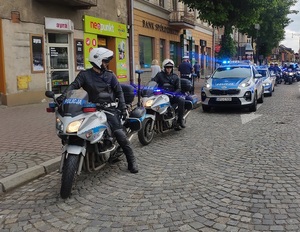Policjanci na motocyklach i radiowozy na poboczu