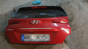 Zdjęcie przedstawia zdemontowaną klapę bagażnika pochodzącą od pojazdu marki Hyundai Krona, leży ona na posadzce