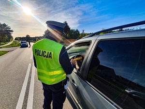 Policjant bada stan trzeźwości kierowcy