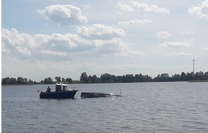 łódź policyjna i zatopiona żaglówka na jeziorze