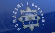 gwiazda policyjna na drzwiach radiowozu z napisem policja 112, wokół niej napis pomagamy i chronimy