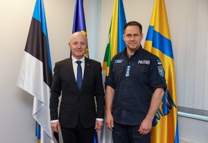 Komendant Główny Policji z Estoński policjantem, z tyłu widać flagi
