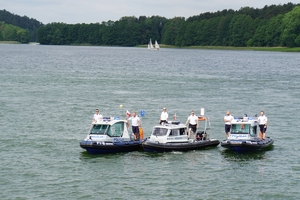 trzy łodzie policyjne na jeziorze a na nich policjanci
