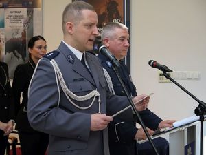 Oficer policji w niebieskim mundurze przemawia do mikrofonu