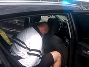 zatrzymany mężczyzna na tylnym siedzeniu policyjnego radiowozu