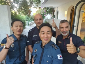 Zdjęcie czterech umundurowanych policjantów, wśród nich polski policjant. Dwaj mężczyźni o wyraźnych rysach azjatyckich