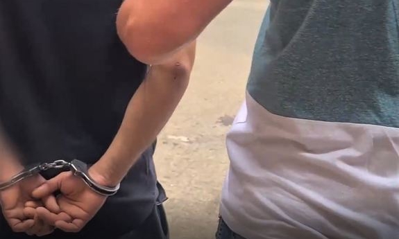 zatrzymany w kajdankach prowadzony przez nieumundurowanego policjanta