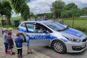 Radiowóz policyjny, w którym siedzą dzieci.