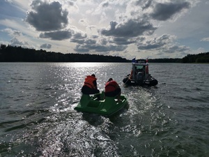 Jezioro, łódź policyjna holuje rower wodny