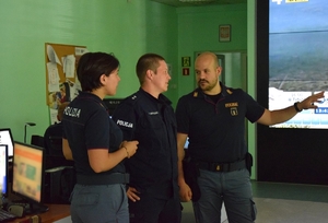Zdjęcie przestawiające trójkę umundurowanych funkcjonariuszy Policji polskiej i włoskiej podczas wizyty na stanowisku kierowania