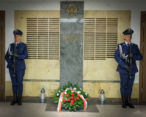 kierownictwo polskiej Policji przed tablica pamięci w trakcie składania kwiatów