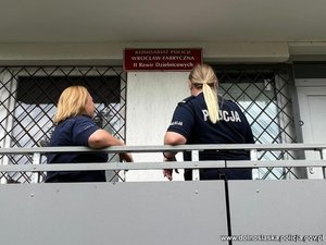 dwie policjantki w mundurach stojące koło komisariatu