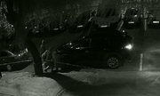 zdjęcie z monitoringu miejskiego, na którym zamaskowani mężczyźni próbują ukraść samochód