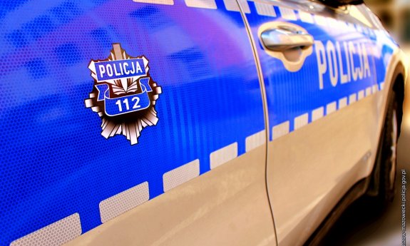 logo policji i ruchu drogowego na niebieskim tle na drzwiach radiowozu
