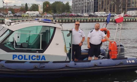 dwaj policjanci stoją na łodzi policyjnej