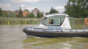 Policjant w łodzi policyjnej na środku akwenu wodnego.