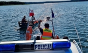 policjanci holują łodzią policyjna katamaran