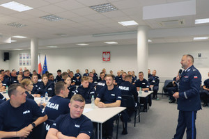 policjanci siedzący przy stołach w trakcie szkolenia